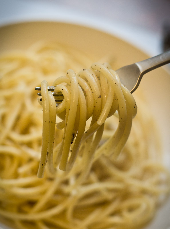 A bowl of cooked cacio e pepe, with fork