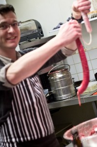 Joby filling a hog casing with black pudding mix